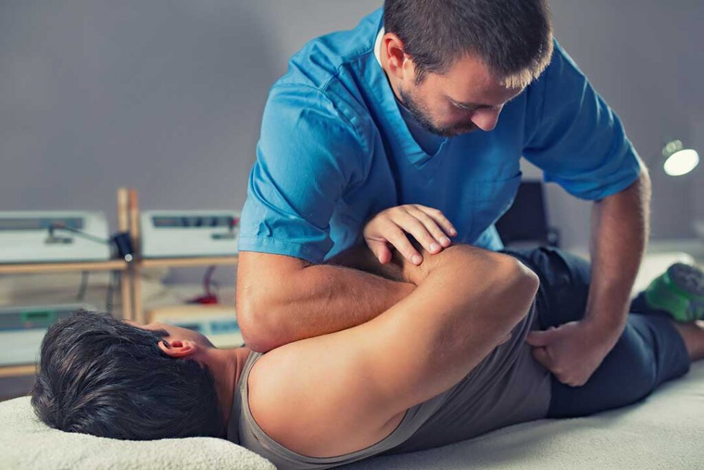 Person rolling onto their side and lowering their legs from a bed before standing carefully.